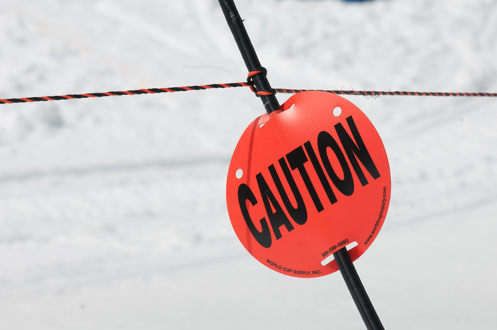 Red caution sign on a rope barrier