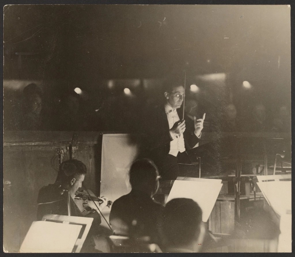 An orchestra conductor directing musicians