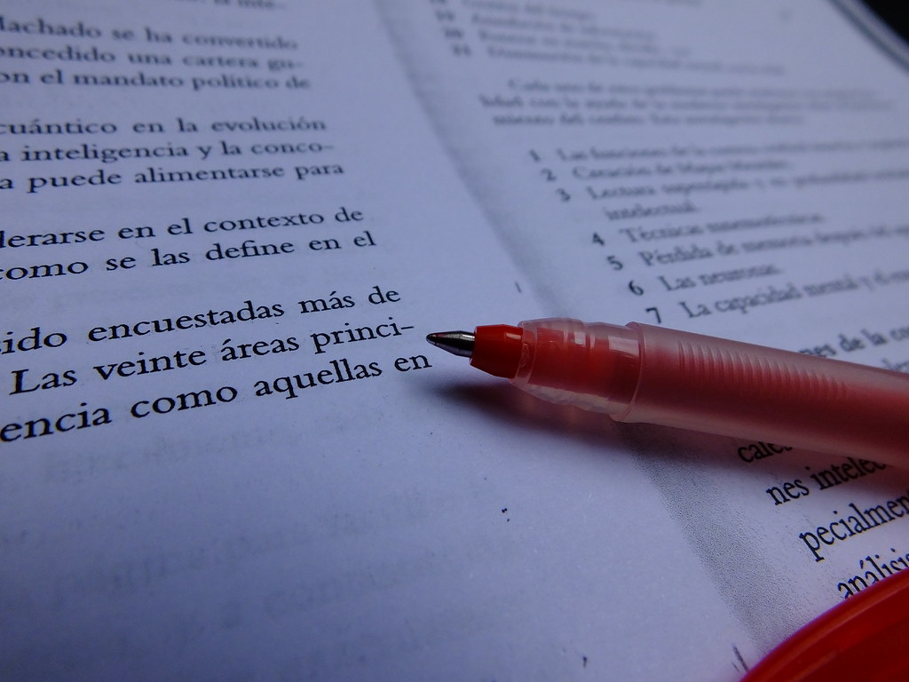 A red pen marking text during review