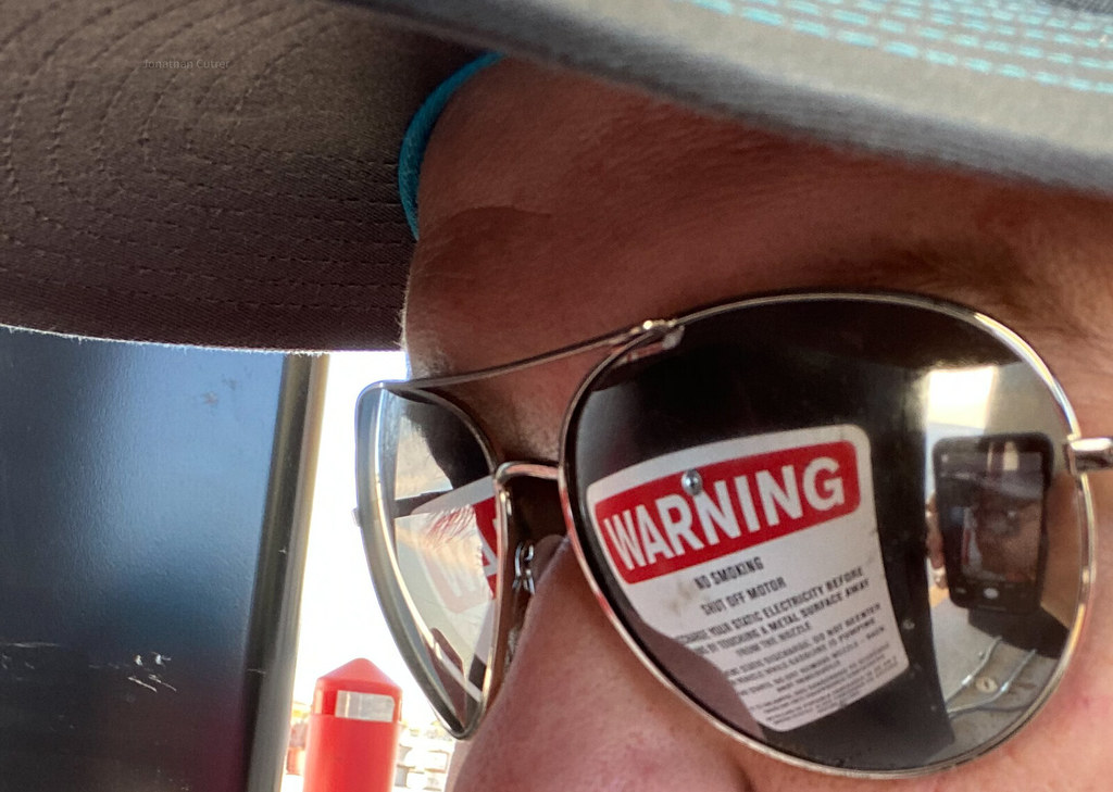 A warning sign reflected in sunglasses
